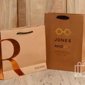 Dos bolsas de papel marrones con logotipos de Roschier y Jones and Co
