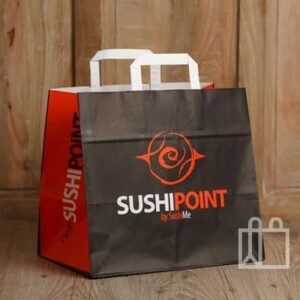Bolsa de papel personalizada para comida para llevar “SUSHIPOINT”, en negro y rojo con asas blancas, sobre fondo de madera.